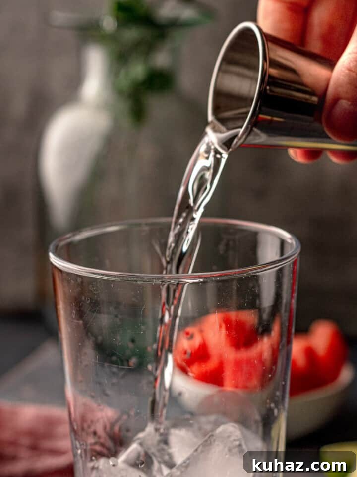 Spicy Watermelon Margarita Recipe with Jalapeño and Lime 4 Tequila being poured.