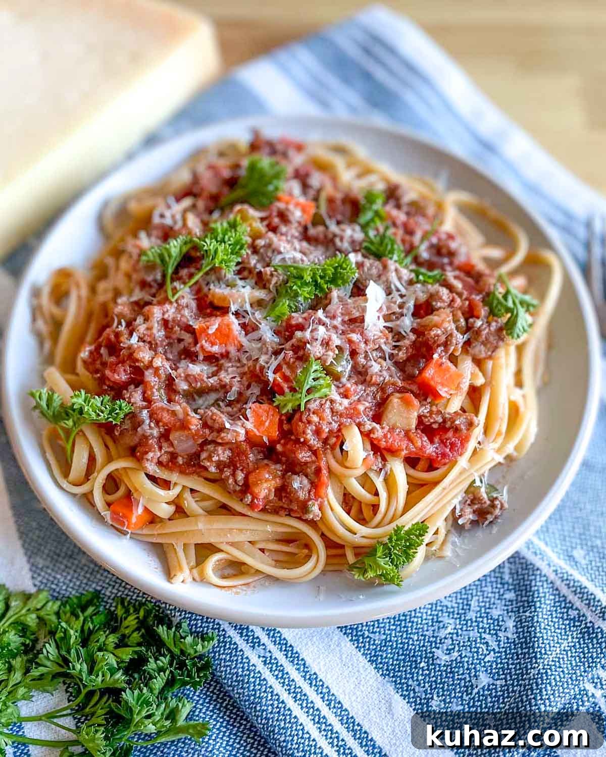 Linguine with Classic Bolognese Sauce 2 A plate of linguine bolognese is topped with parmesan cheese and parsley.