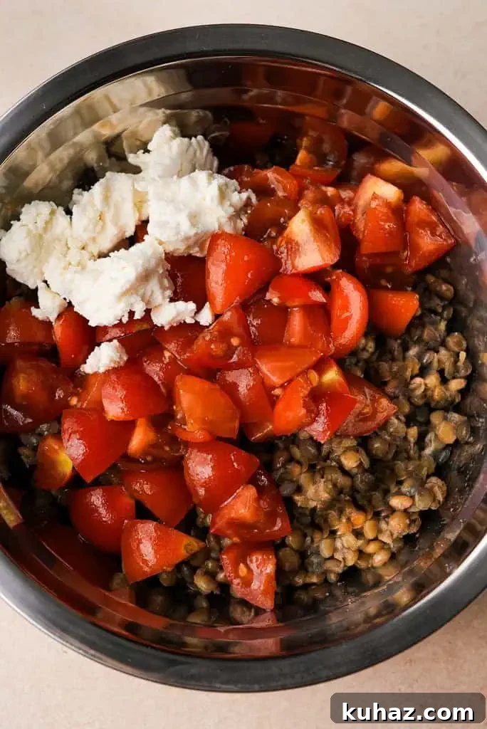 Lentil salad feta lentils, tomatoes, and feta in a mixing bowl