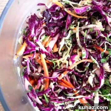 greek yogurt coleslaw with crunchy cabbage, carrots, cilantro, and creamy dressing in a bowl.