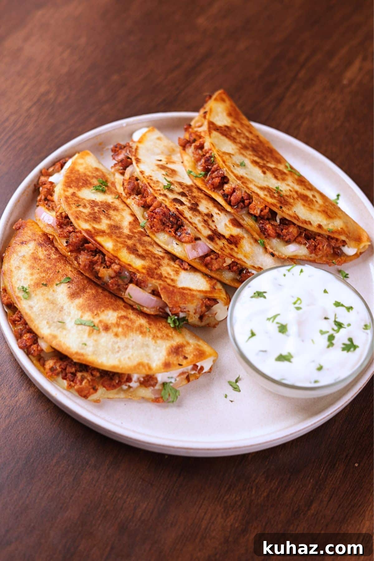 Crispy Ground Chicken Tacos with Crunchy Shells 6 Crispy ground chicken tacos served on a white plate with creamy sauce on the side.