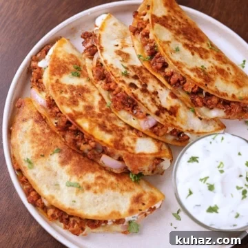Crispy Ground Chicken Tacos with Crunchy Shells 7 Crispy ground chicken tacos served on a white plate with creamy garlic sauce on the side.