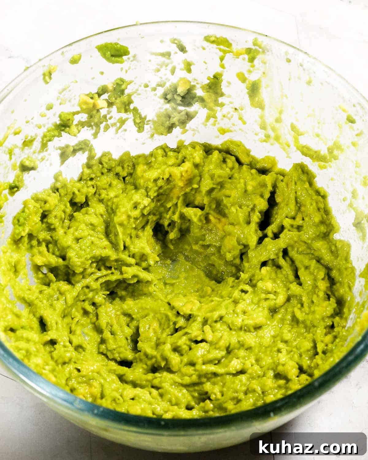 Avocado Chocolate Frosting Recipe — Creamy Dairy-Free 4 Mashed avocado in a glass bowl.