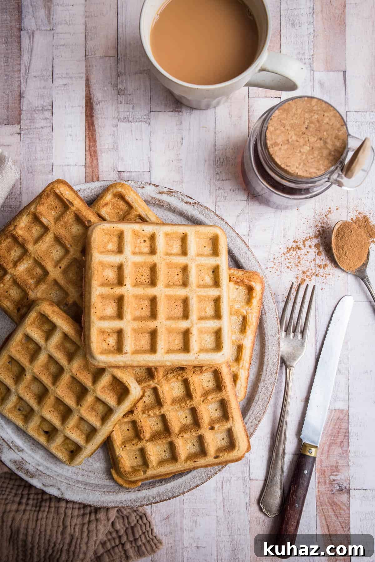 Gluten-Free Waffles: Quick, Crispy and Fluffy Recipe 6 Gluten-free waffles on a plate on a table next to cutlery and cinnamon