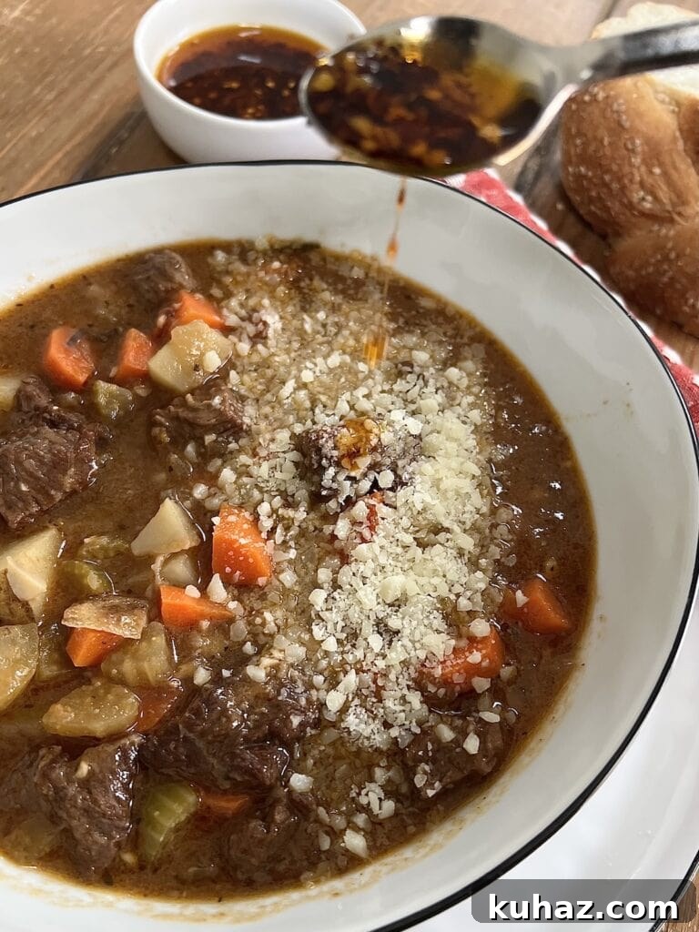 Italian Beef and Potato Soup - Nonna Pot-Roast 12 Drizzling some spicy oil over a bowlful of beef veg soup garnished with grated cheese.