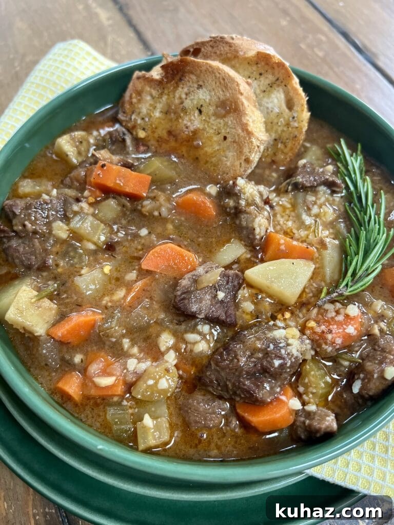 Italian Beef and Potato Soup - Nonna Pot-Roast 3 Nonna's pot roast soup in green soup bowl with 2 slices toasted bread and rosemary sprig garnish.