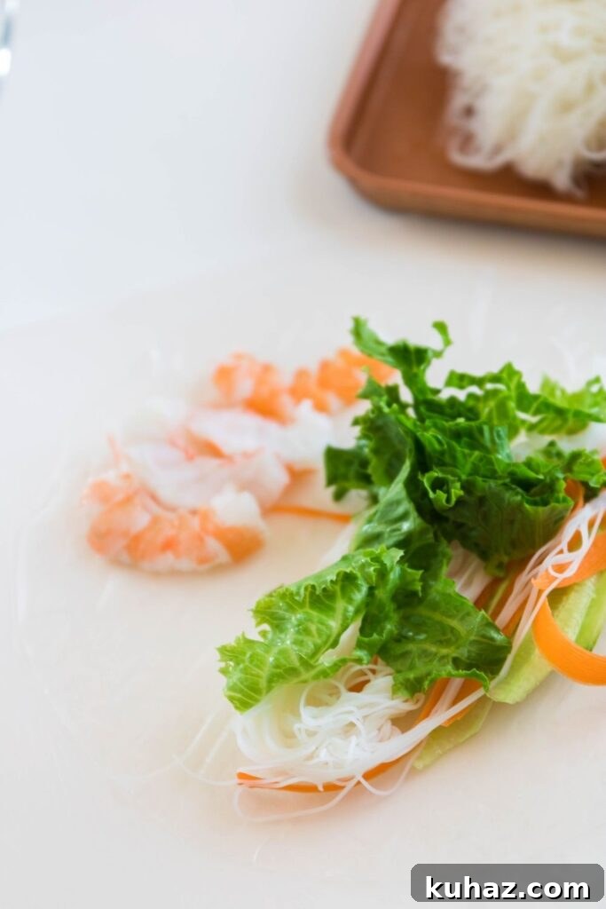 Vietnamese Shrimp Spring Rolls Recipe 4 spring roll on a cutting board filled with vegetables and shrimp