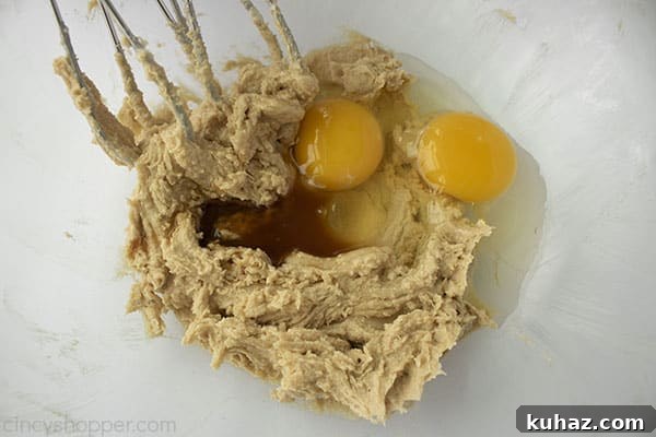 Moist Cinnamon Apple Muffins Recipe 8 Muffin mixture with eggs and vanilla in bowl with mixing beaters.