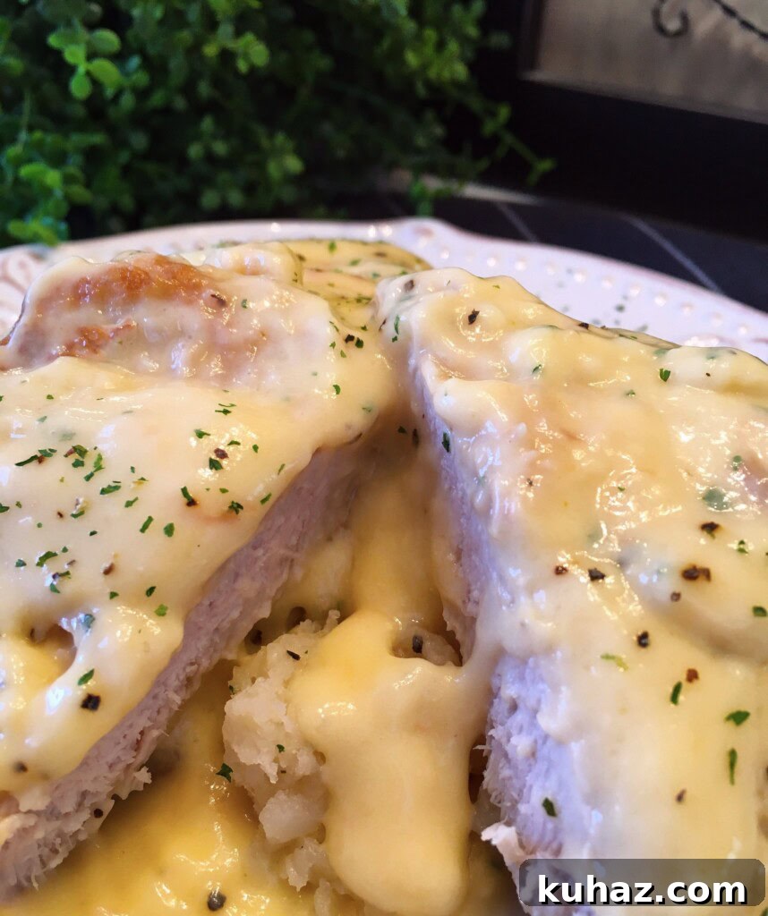 Slow Cooker Chicken Fried Country Pork Chops 8 Pork Chop cut in half with gravy on top of mashed potatoes.