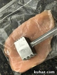 pounding chicken breast inside a ziplock bag