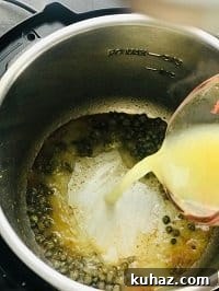 pouring chicken stock in instant pot to deglaze it