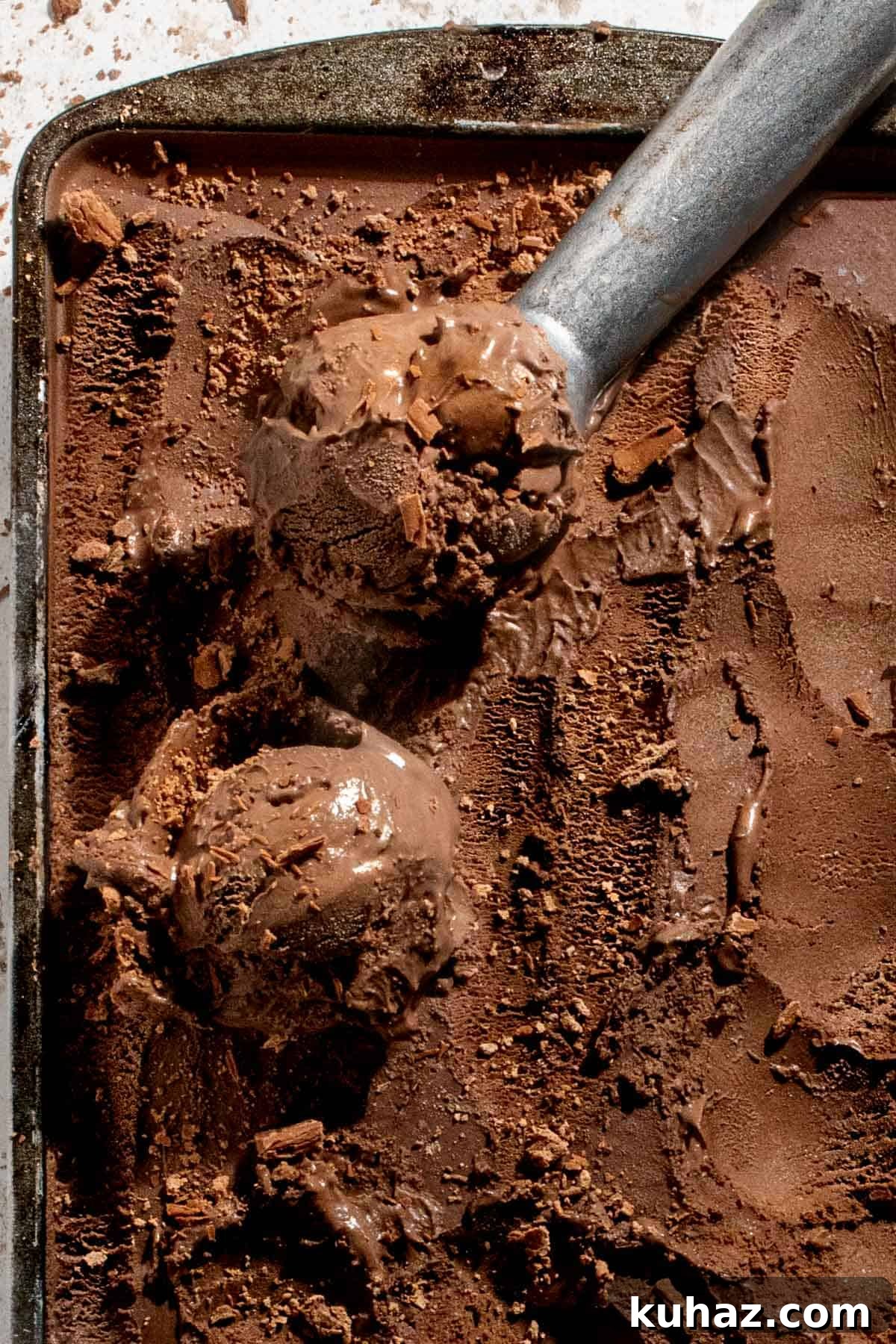 No-Churn Dark Chocolate Ice Cream Recipe 2 Dark chocolate ice cream in a baking tray with an ice cream scoop.