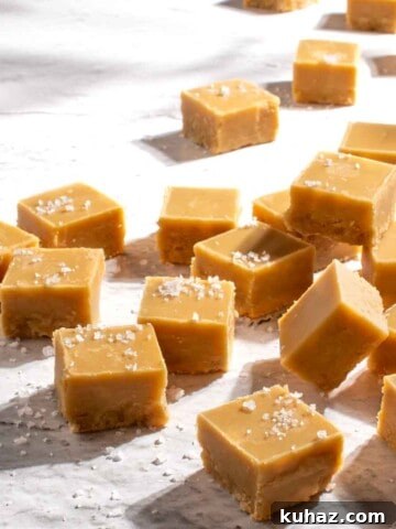 Microwave peanut butter fudge scattered across a rough, white surface.