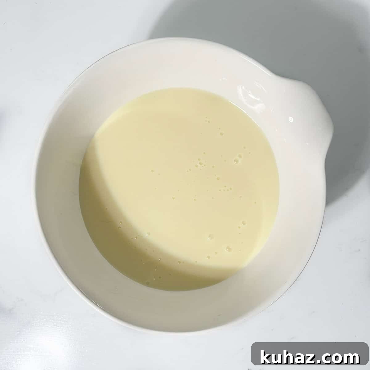 No-Churn Dark Chocolate Ice Cream Recipe 6 Condensed milk in a small white bowl for the dark chocolate ice cream.