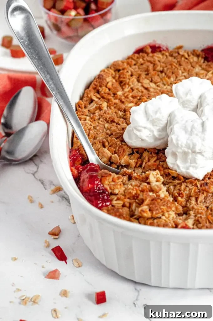 A delicious pink rhubarb crisp topped with golden brown oat crisp topping and served with fresh whipped cream.
