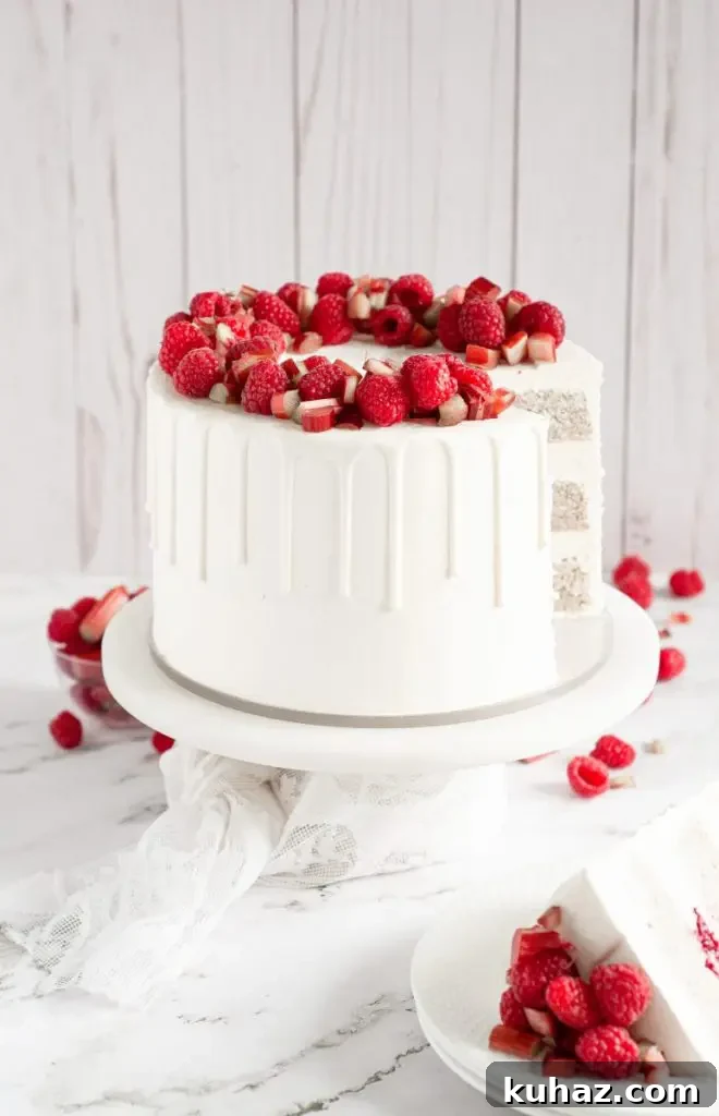 A bright white almond cake topped with fresh raspberries and rhubarb.