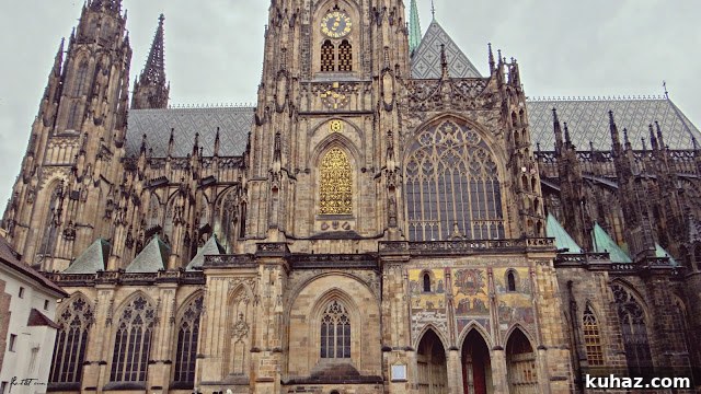 A large stone building with a clock on the front of a church