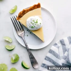 Slice of creamy key lime pie with a dollop of whipped cream on top.