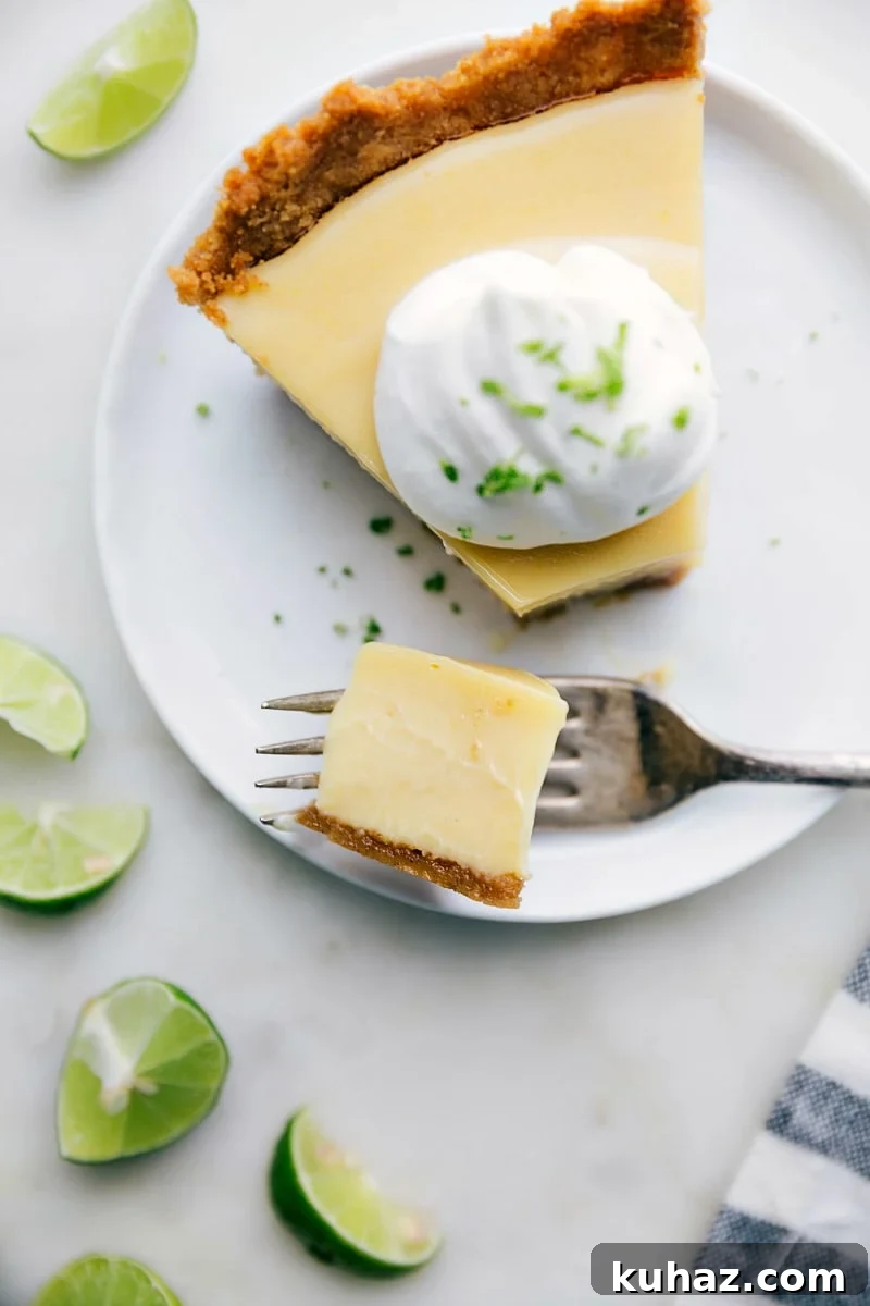 Classic Key Lime Pie Recipe with Graham Cracker Crust 3 A delicious sweet and tangy slice of dessert with a bite taken out of it.