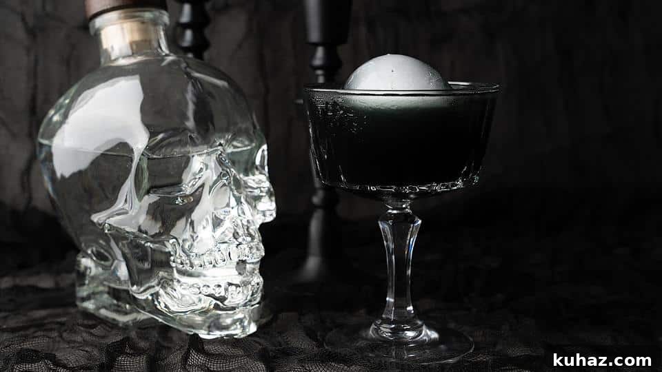Lunar Elixir black Halloween cosmopolitan cocktail with an ice ball.
