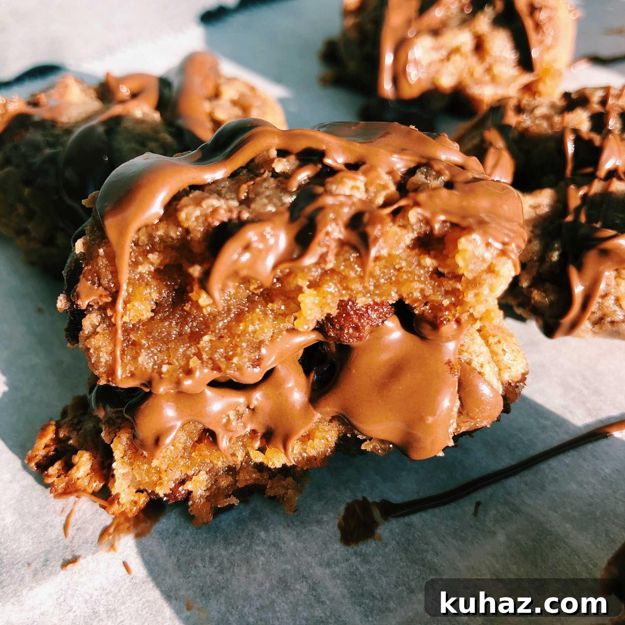 Almond Butter Blossom Cookies 5 Almond Butter blossom broke in half and stacked on top of each other with chocolate dripping down.