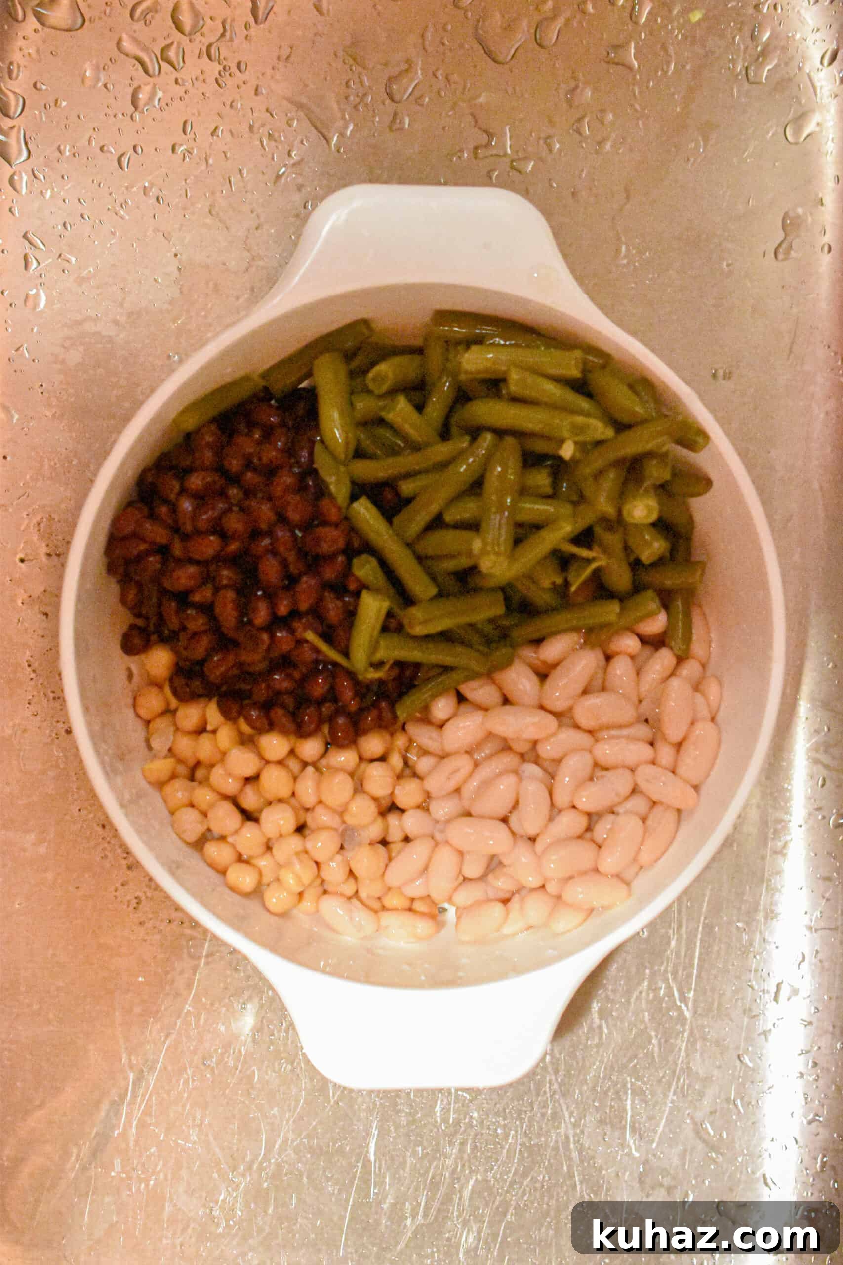 The cans of beans are washed and drained in a colander