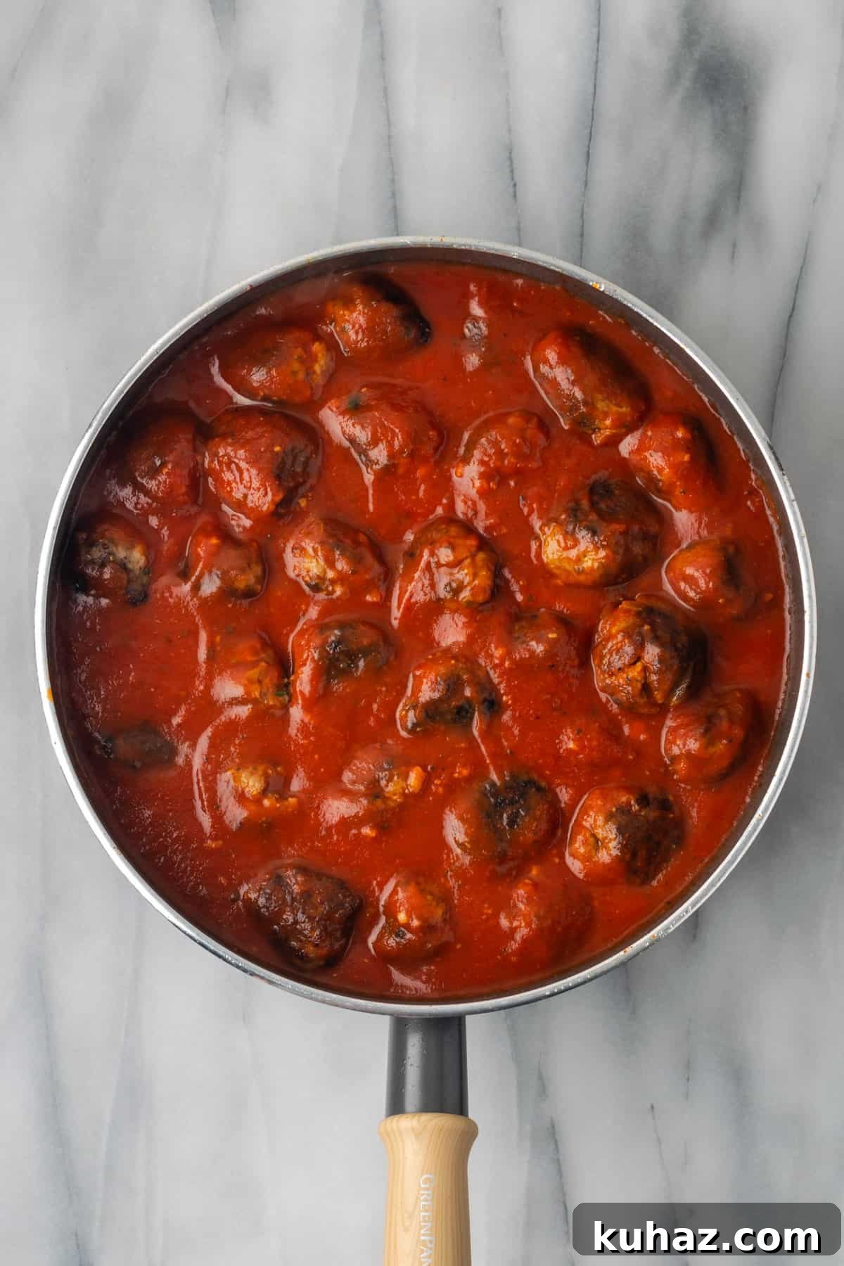 Gluten free meatballs cooking in marinara sauce. 