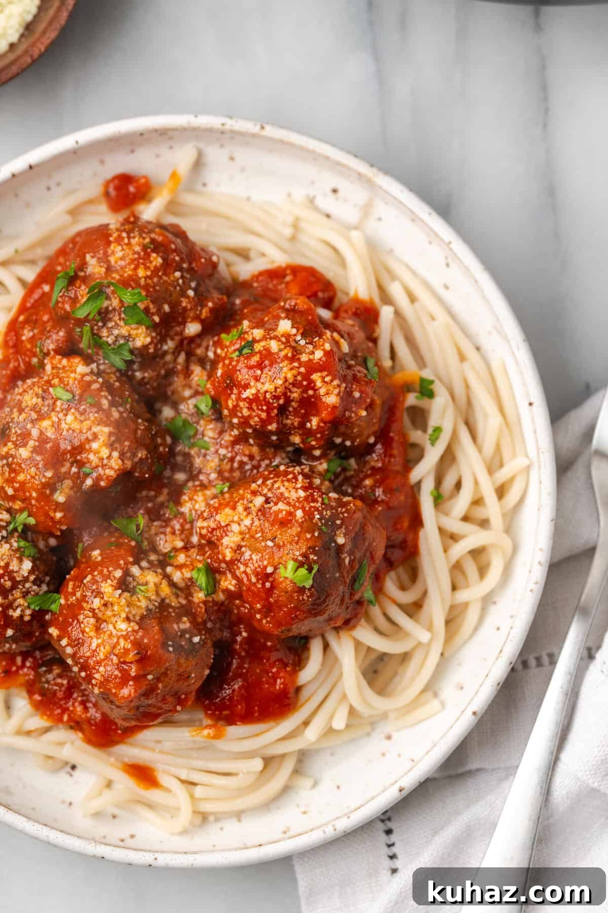 Gluten free meatballs in marinara sauce served over gluten free spaghetti noodles.