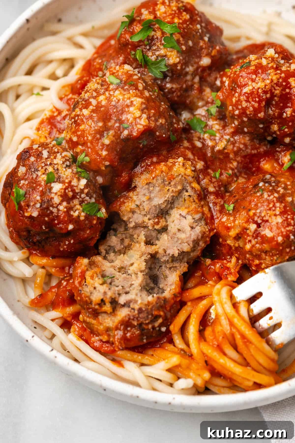 A gluten free meatball cut open with a fork. 
