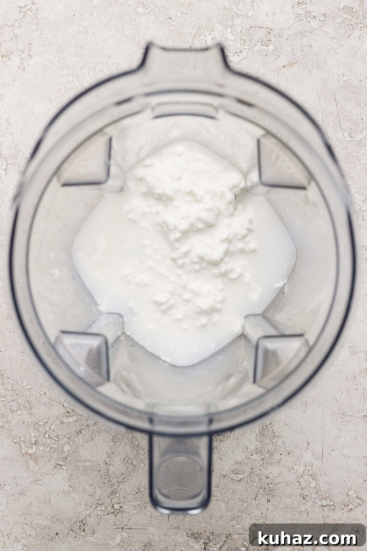 Tiramisu Crepe Roll with Cottage Cheese 4 Blender jug with foamy white liquid inside, viewed from above.
