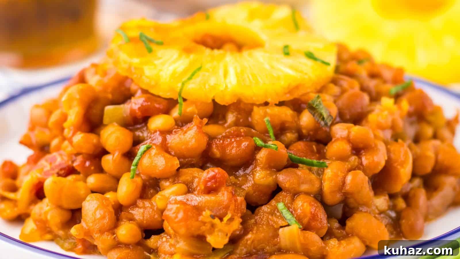 19 BBQ Dinner Recipes That Made Dad Stop Asking What's Next 13 A plate of Hawaiian baked beans garnished with a pineapple slice and chopped herbs.