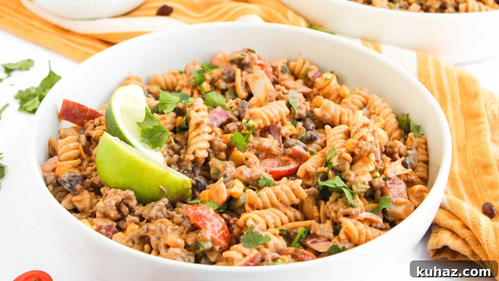 19 BBQ Dinner Recipes That Made Dad Stop Asking What's Next 19 A bowl of fusilli pasta mixed with ground beef, black beans, chopped tomatoes, and herbs, garnished with lime wedges.