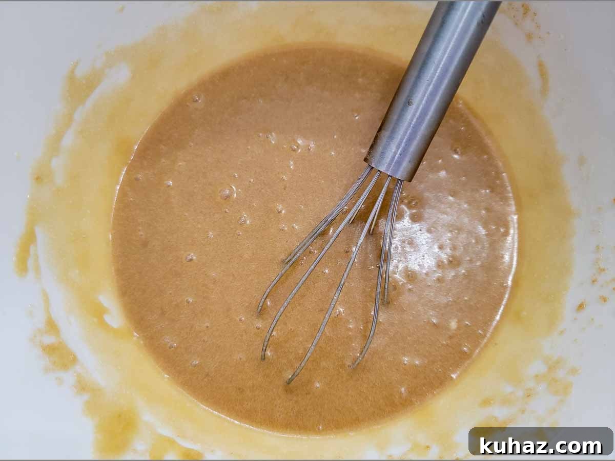 Maui Banana Bread Recipe with Coconut and Macadamia Nuts 3 banana bread wet ingredients whisked in a bowl.
