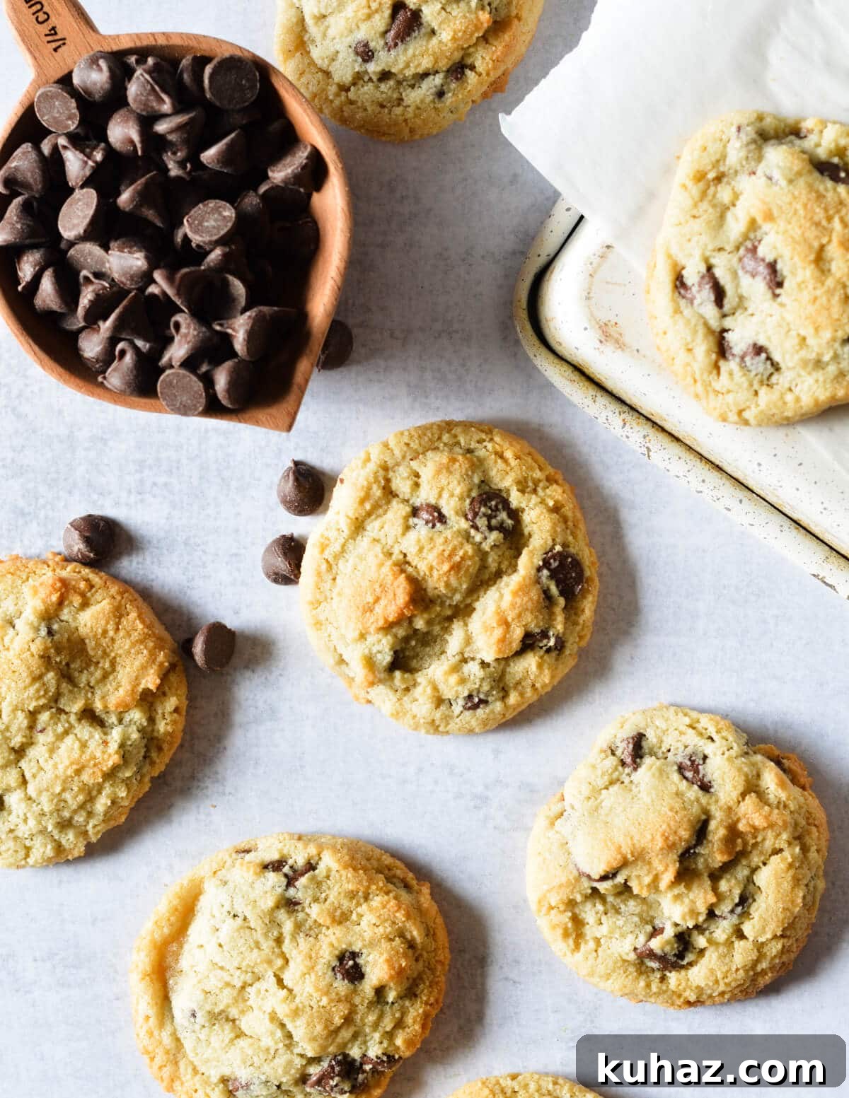 Soft and Chewy Almond Flour Chocolate Chip Cookie Recipe 2 almond flour chocolate chip cookies near a cup of chocolate chips.