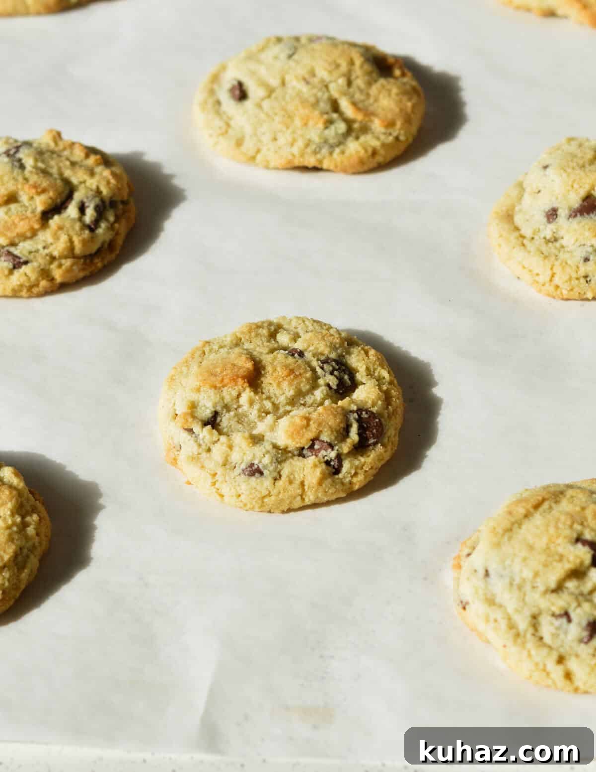 Soft and Chewy Almond Flour Chocolate Chip Cookie Recipe 9 baked chocolate chip cookies on a sheet pan.