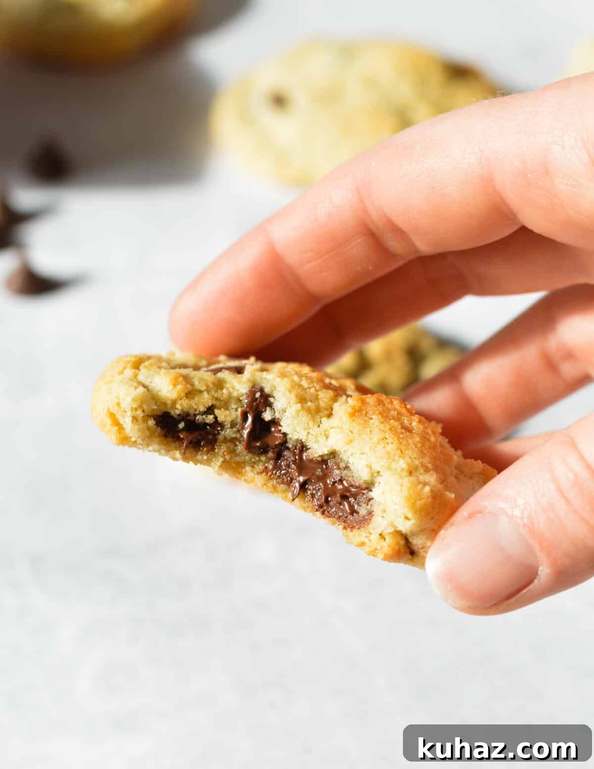 Soft and Chewy Almond Flour Chocolate Chip Cookie Recipe 12 hand holding a cookie with melted chocolate in the center.