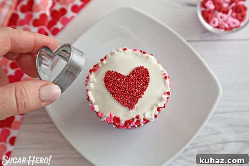 Removing a cookie cutter from the top of a frosted cupcake