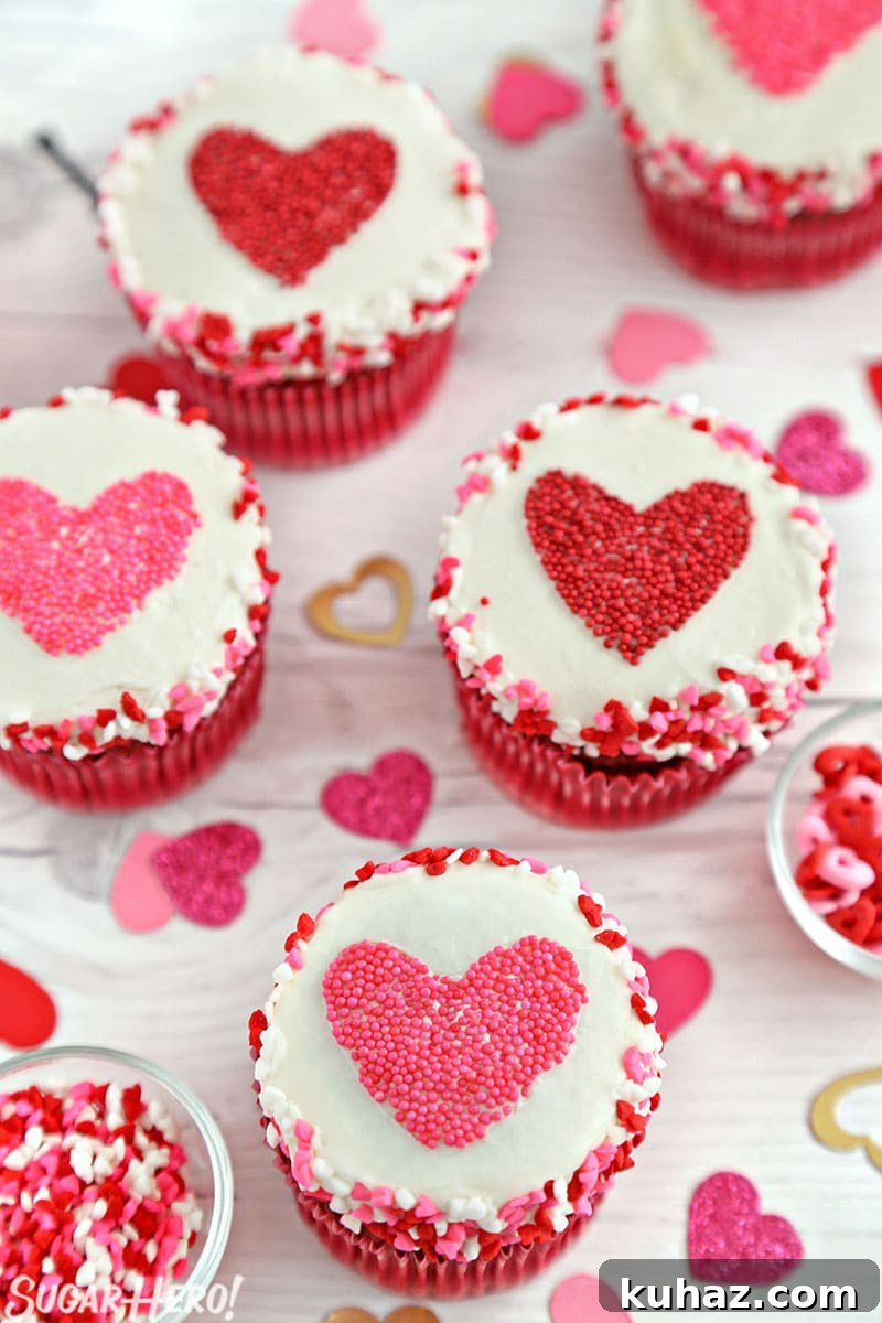 Group of cupcakes with red and pink heart-shaped sprinkle shapes in the center