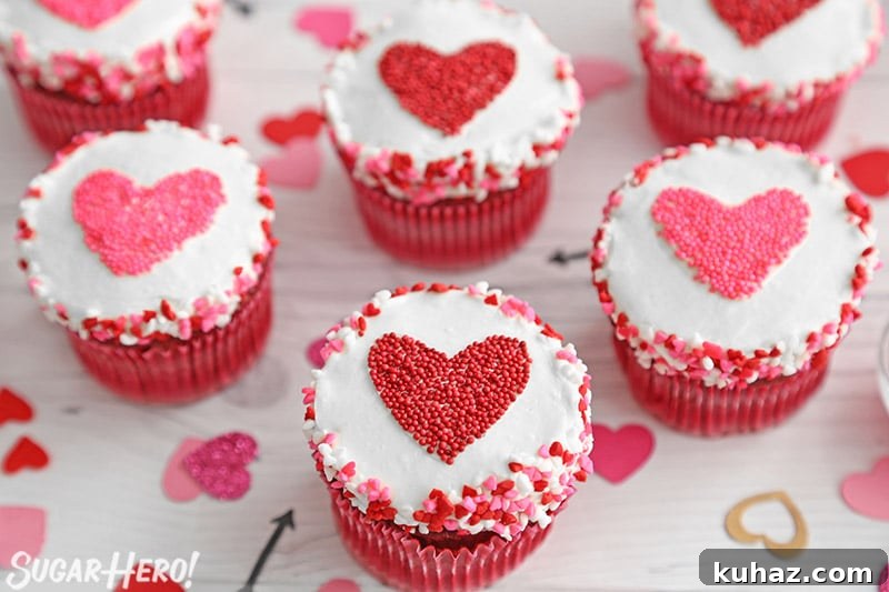 Group of cupcakes with red and pink hearts made of sprinkles in the center