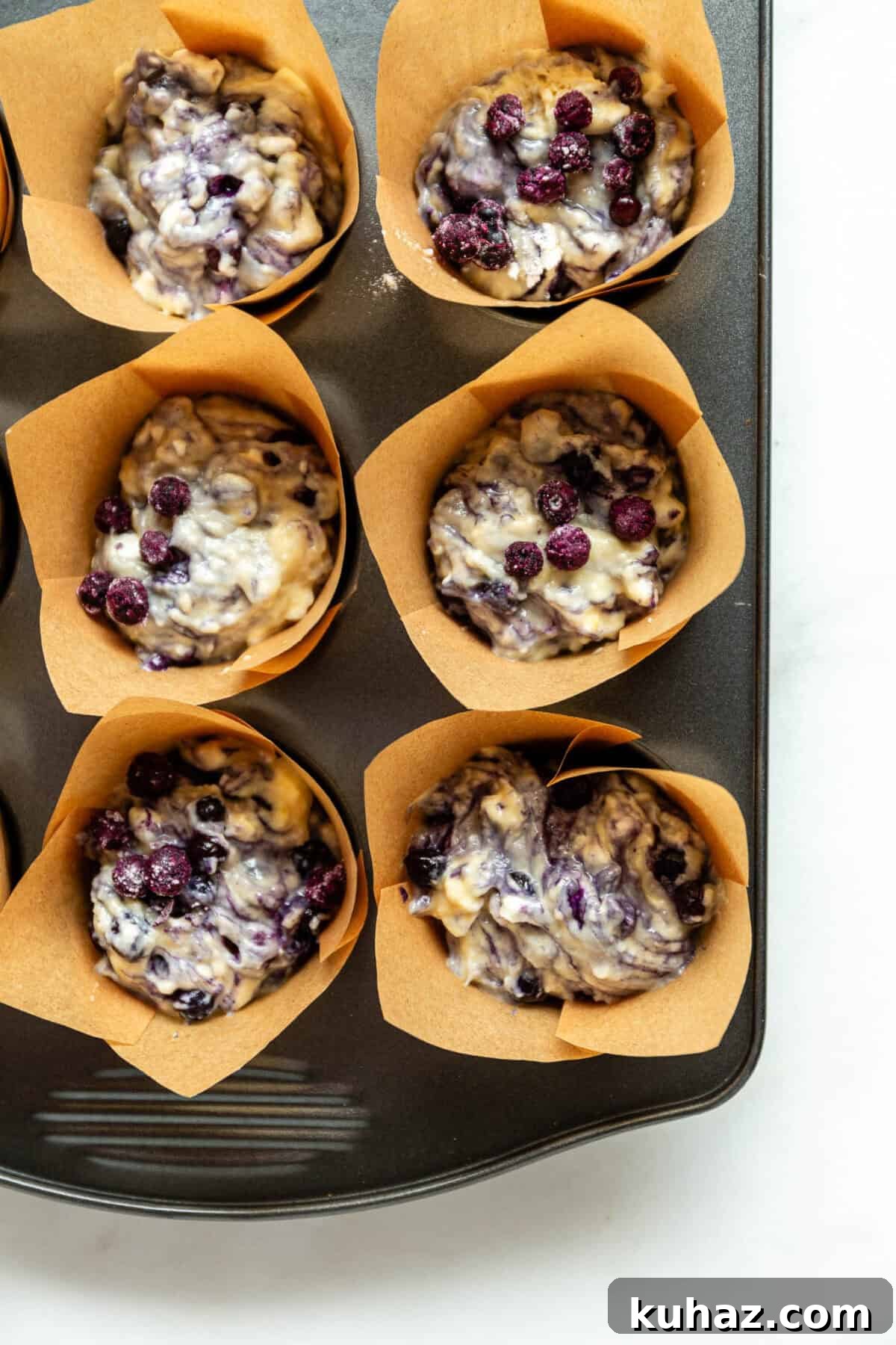 blueberry muffin batter in a muffin pan.