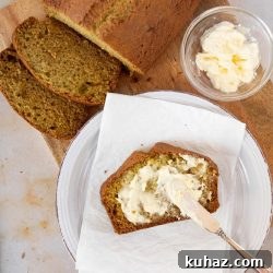 Moist Zucchini Bread Recipe 4 Overhead shot of a loaf of zucchini bread with a slice being spread with clotted cream and text Zucchini Sweet Bread, recipes and ideas using zucchini