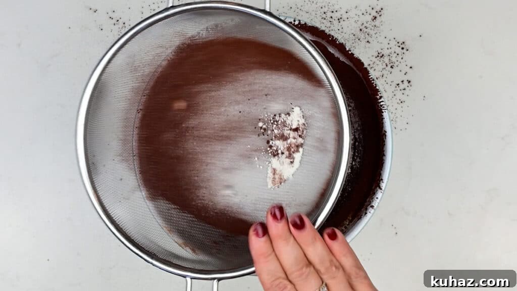Salted Caramel Brownies Recipe with Gooey Caramel Swirls 6 sifting flour and cocoa powder into brownie batter