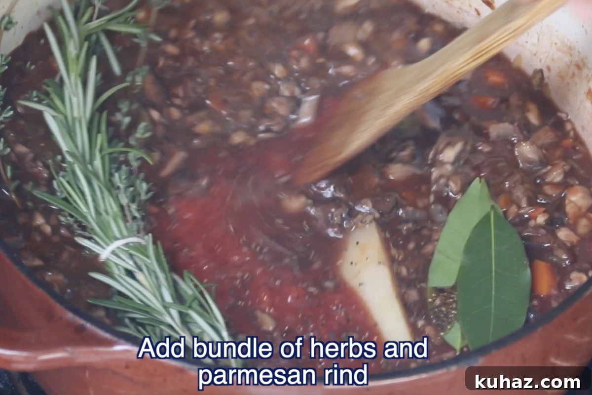 adding herbs and parmesan rind to ragu