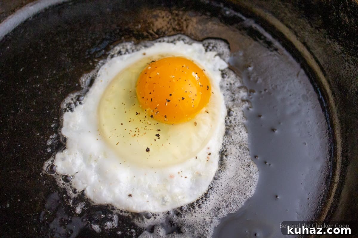 How to Make Perfect Sunny Side Up Eggs 5 An egg frying in a cast iron skillet.