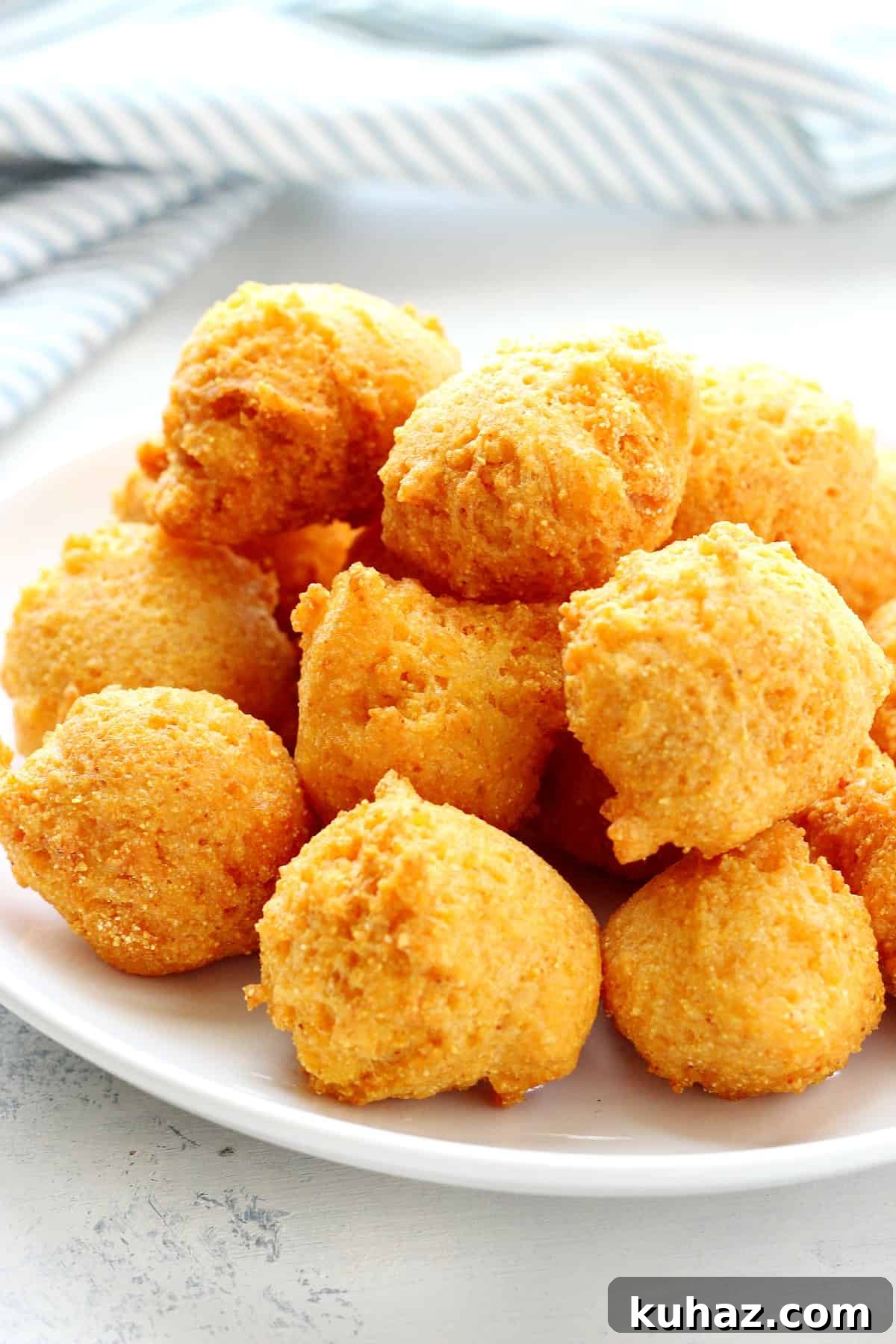 Easy Hush Puppies Recipe Fried hush puppies on a white plate.