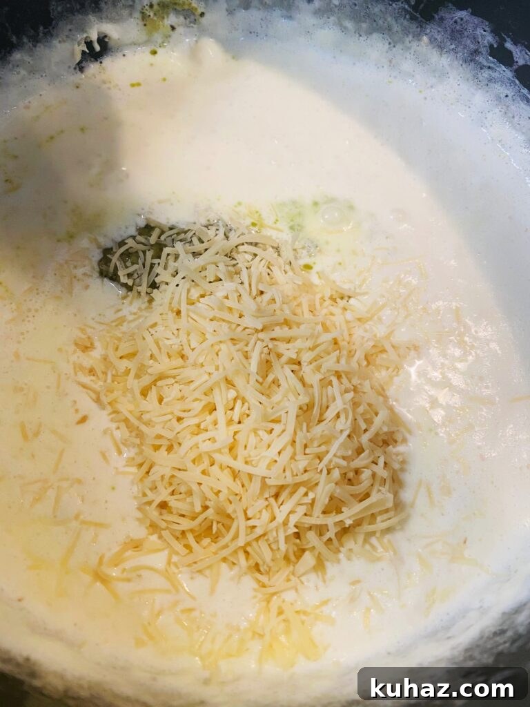 Creamy Pesto Salmon Pasta 5 adding cheese to the cream