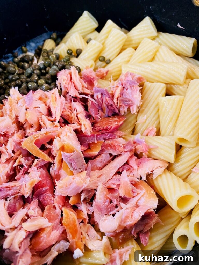Creamy Pesto Salmon Pasta 6 adding salmon and capers to the sauce
