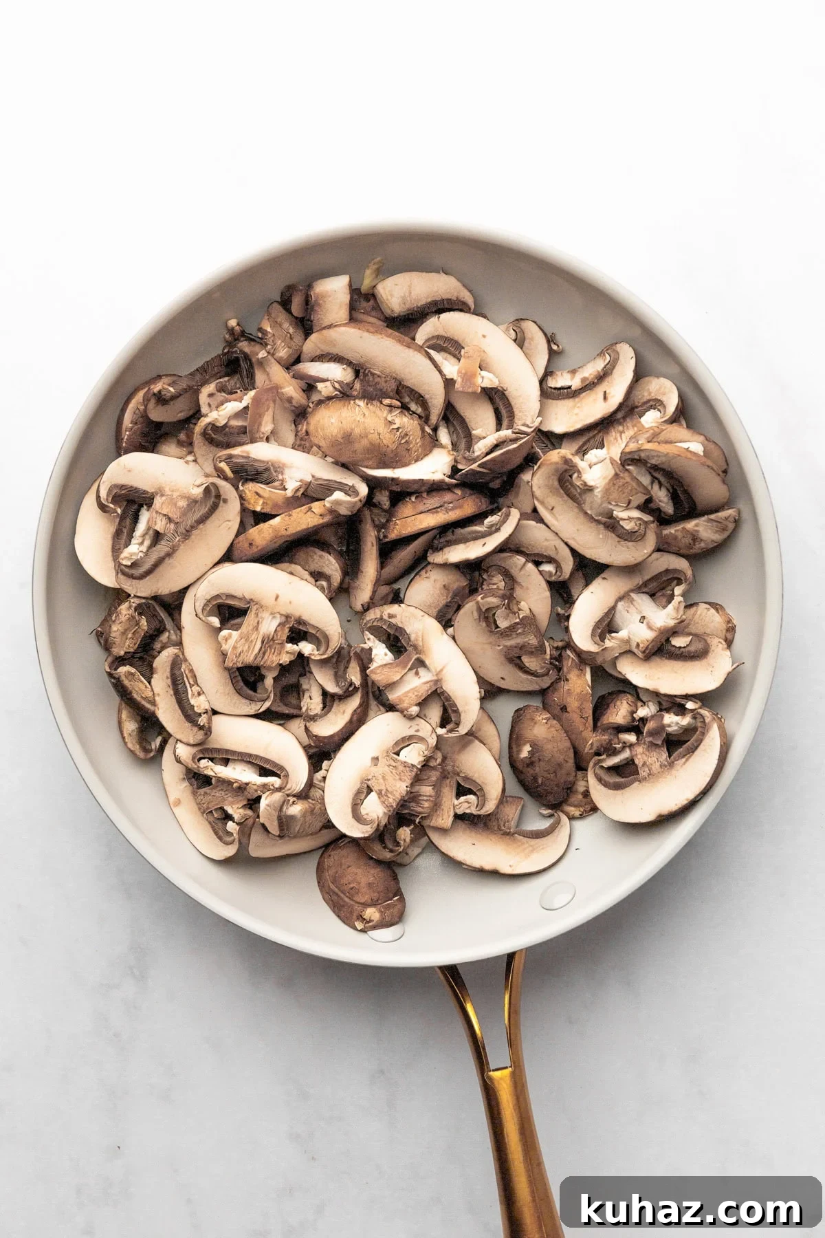 Creamy Mushroom Pasta with Garlic and Parmesan 4 An overhead image of sliced mushrooms on a skillet.