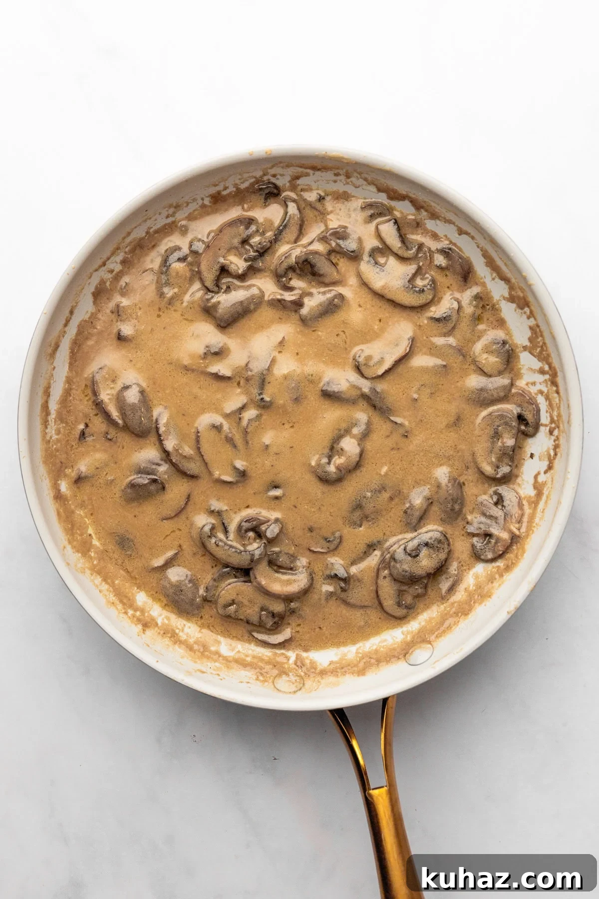 Creamy Mushroom Pasta with Garlic and Parmesan 6 An overhead image of adding white wine, then heavy cream, and seasonings to the sauce.