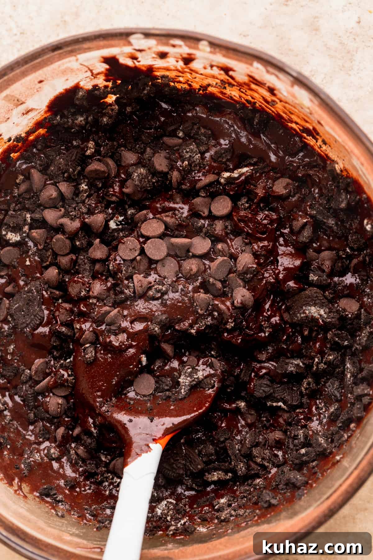 Fudgy Oreo-Stuffed Brownies Recipe 5 Oreos on top of of brownie batter in a glass bowl.